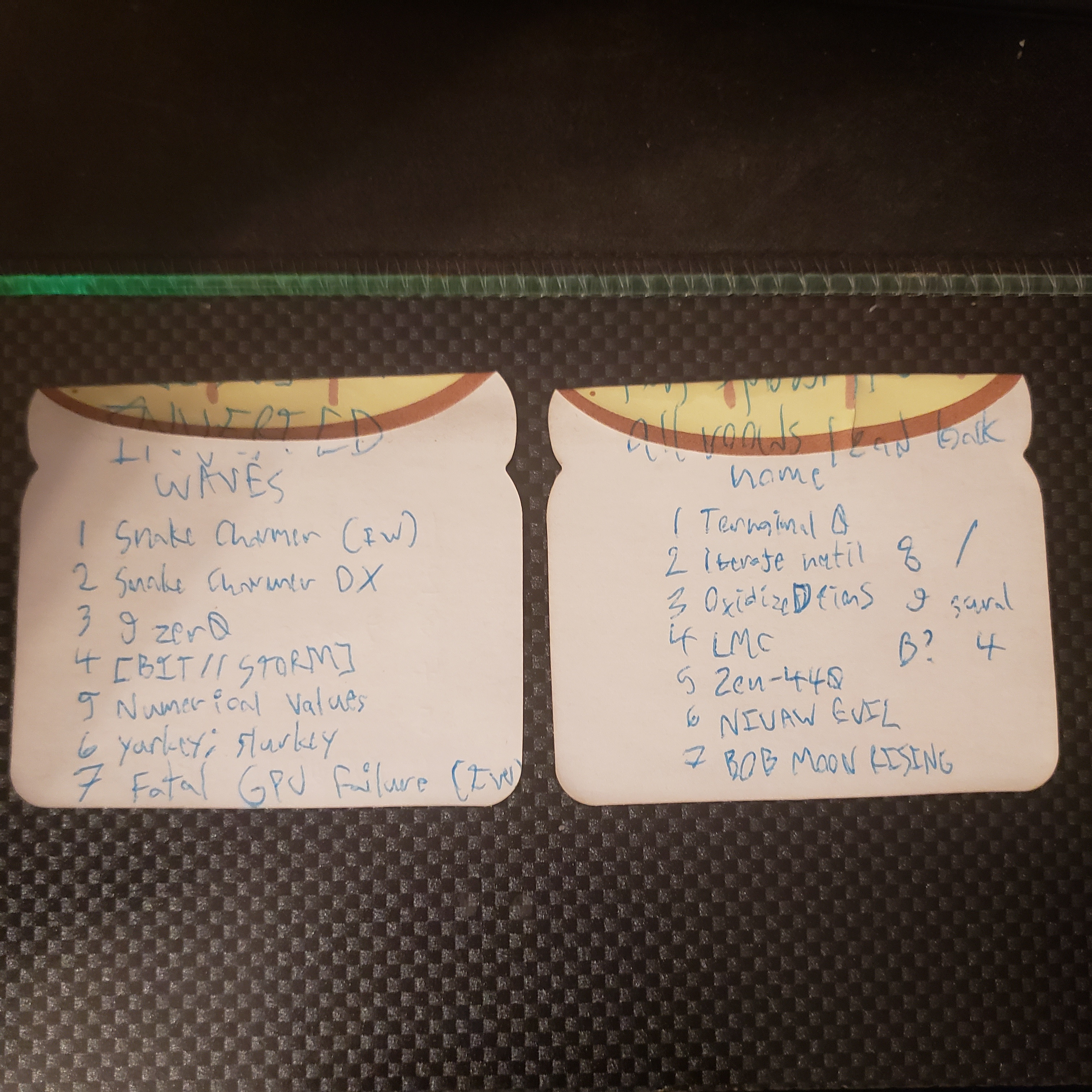 Two bread sticky notes. First one says: Inverted Waves. 1, Snake Charmer, I.W. 2, Snake Charmer D.X. 3, Nine Zero. 4, Bit Storm. 5, Numerical Values. 6, yurkey semicolon slurkey. 7, Fatal G.P.U. Failure, I.W. End of first sticky note. Second sticky note says: all roads lead back home. 1, Terminal Zero. 2, Iterate Until. 3, Oxidized Pins. 4, L.M.C. 5, Zen 440. 6, N.I.V.A.W. EVIL. 7, Bob Moon Rising. 8, forward slash. 9, sural. B with a question mark, Four.